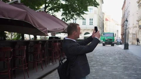 Side view of man walking on ancient street with beautiful medieval facade, male Stock Footage 181859988
