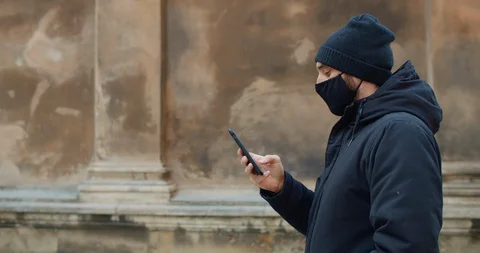Side view of man walking and using his smartphone for communicating in social Stock Footage 127894441