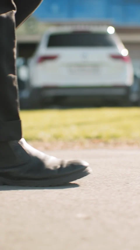 Side View of Man Walking on Tarred Road Near Cars and Urban Building on Sunny Stock Footage 310813286