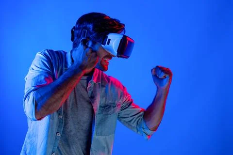 Side view of man wearing VR glass and smashing or punching at camera. Deviation. Stock Photos
