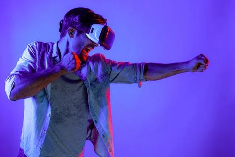Side view of man wearing VR glass and smashing or punching at camera. Deviation. Stock Photos