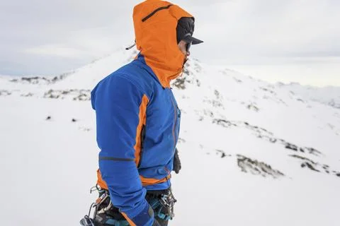 Side view of man on windy mountain summit, warm clothing Stock Photos