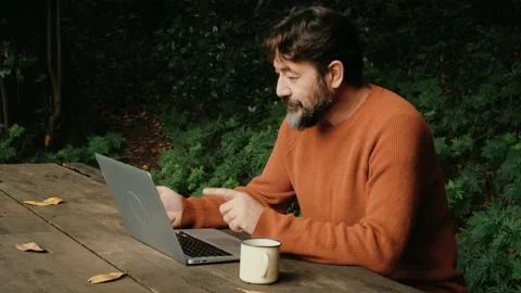 Side view of a man working with connection online and laptop computer in outd Stock Footage 169265538