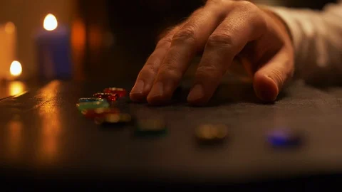 Side view of a man's hand, which lays out colored stones on table in semicircle Video stock 105736152