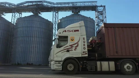 Side view of many trucks with trailers full of grain waiting to unload goods at  Stock Footage 155491106