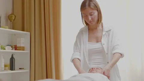Side view of masseur hands with cream doing cosmetic procedure facial massage. Stock Footage 197659045