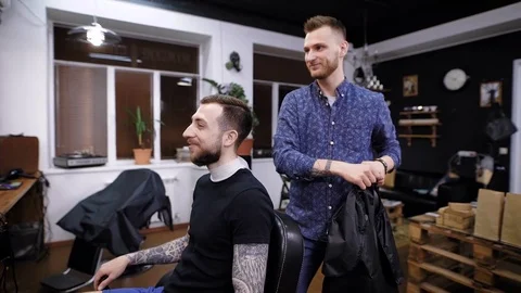 Side view of master combing hair to male customer in barber shop Stock Footage