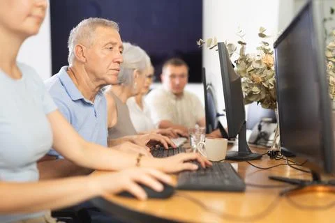 Side view of mature people while studying in computer lab in nursing home 写真素材