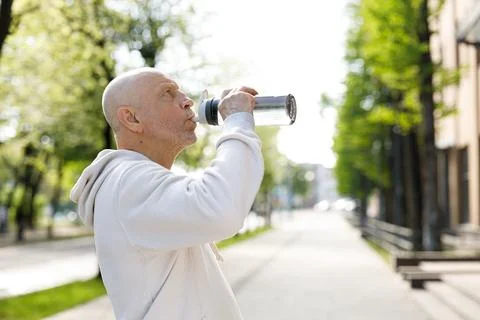 Side View of the Mature Runner Drinking Water from the Sport Bottle After Stock Photos