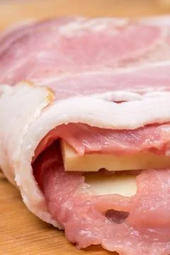 Side view of meat stuffed with yellow cheese and rolled in bacon Stock Photos