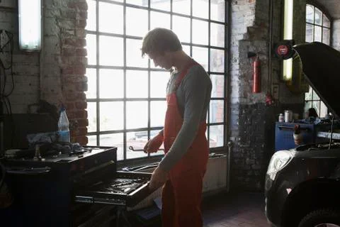 Side view of mechanic removing work tools from drawer at garage 스톡 사진