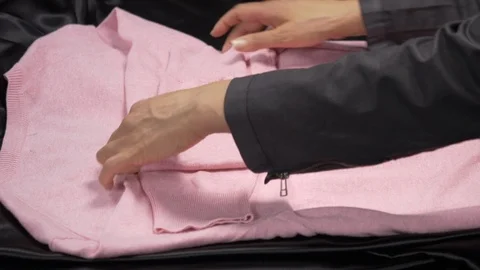 Side view-merchandiser folding a pink luxury Men Casual Classic Sweater 4k. Video stock 96293688