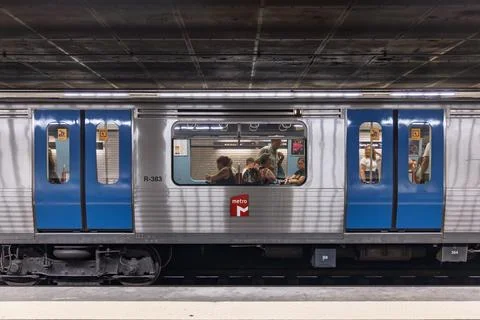 A side view of a metro train stopped at a station platform, with its doors op Foto stock