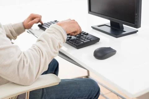 Side view mid section of a man using computer keyboard Fotos de archivo