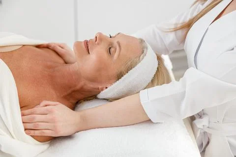 Side view of middle-aged beautiful lady patient lying in beauty cabinet on Stock Photos
