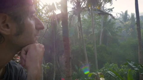 Side view of a middle aged man thinking while overlooking the jungle Stock Footage 57799375