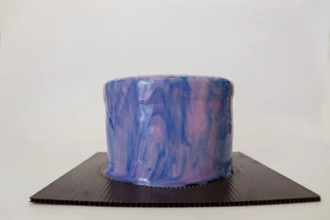 A Side view of a mirror glazed cake with Purple and pink Stock Photos