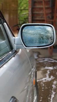 Side view mirror of a gray car in foam splashes Stock Photos