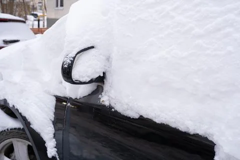 Side view mirror of a parked car almost completely buried under thick snow Stock Photos