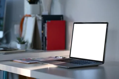 Side view of mock up laptop computer with white screen on graphic designer or Stock Photos