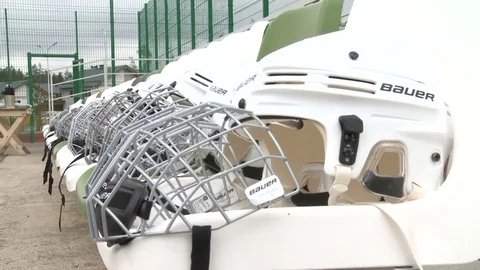 Side View Modern White Bauer Hockey Helmet Line on Long Table Stock Footage 79938867