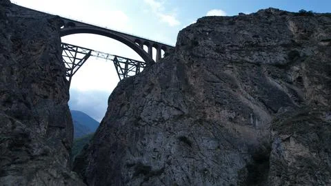 Side view of a mountain arch bridge on Iranian cliffs, concrete span Stock Photos