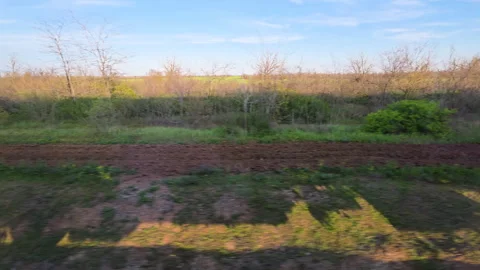 Side view from a moving train window showing a beautiful rural landscape with Stock Footage 335358565