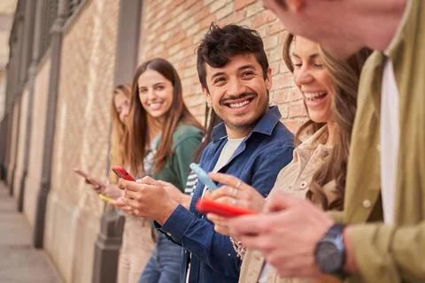 Side view multiracial smiling group young generation z leaning brick wall using Stock Photos