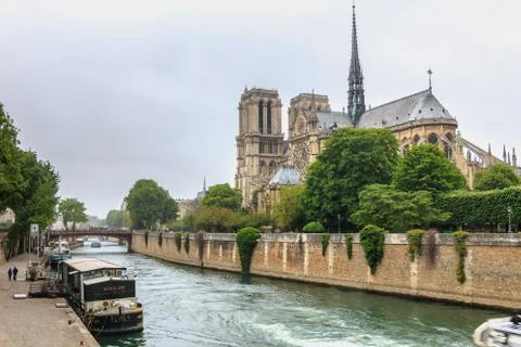 Side view of Notre Dame Cathedral on the Seine with barges Stock Photos