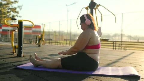 Side view of an obese female doing fitness stretching on a mat. Stock Footage 344249495