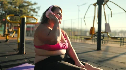Side view of an obese woman doing fitness stretches sitting on a mat. Stock Footage 344249554