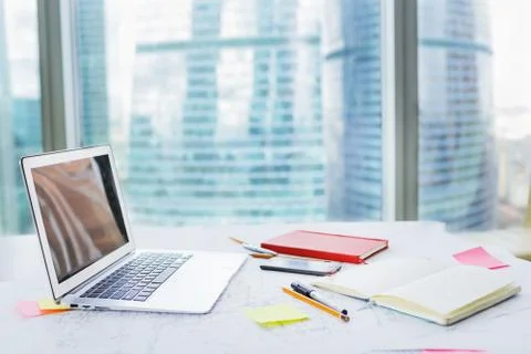 Side view of office workplace with laptop, notebook, smartphone on table by Stock Photos