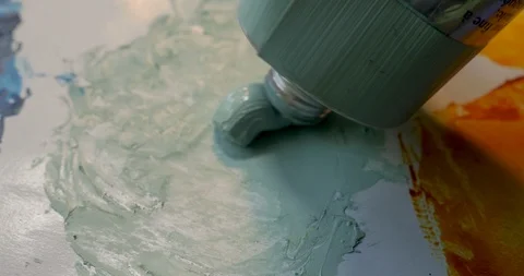 Side view of oil paint coming out of a tube on to a palette Stock Footage 120638822