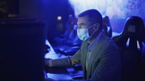 Side view of old man in costume and face mask chatting and surfing Internet in Stock Footage 136392383