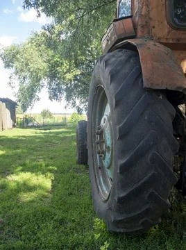 Side view of an old rusty tractor standing on green grass on a Sunny day. Rur Foto stock