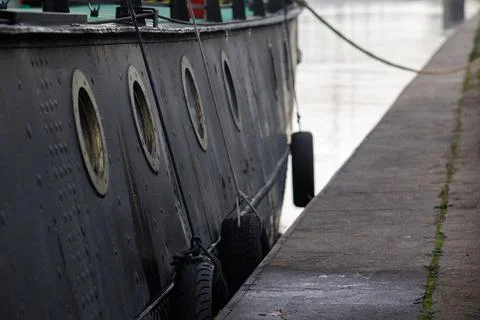 A side view of an old ship with round portholes. The ship's black side with.. Stock Photos