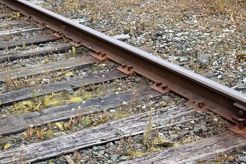 Side view of a old train track plate, spikes, rail and sleepers Stock Photos