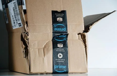 Side view of open and damaged Amazon Prime cardboard parcel box with sticker Foto stock