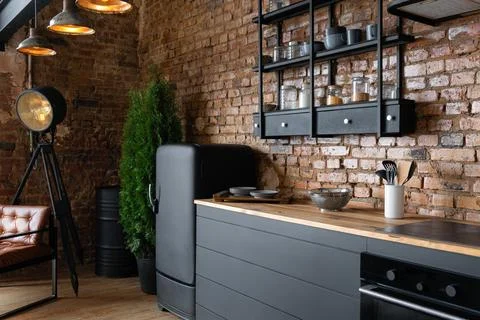 Side view on an open space industrial loft kitchen with vintage decor, black Stockfoto's