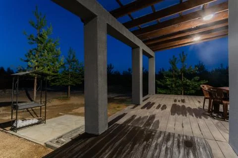 Side view of an open veranda in front of a modern forest cottage. Pine young Stock Photos