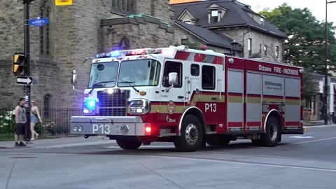 Side view of Ottawa Fire Services pumper truck driving with flashing emergency Stock Footage 341935205