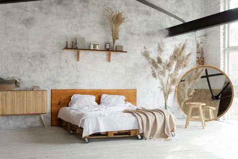 Side view of pacious airy white industrial loft bedroom with bed,  mirror and Stock Photos