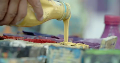 Side view of painting a mural on a wall with brush and roller and palette. Stock Footage 141751228