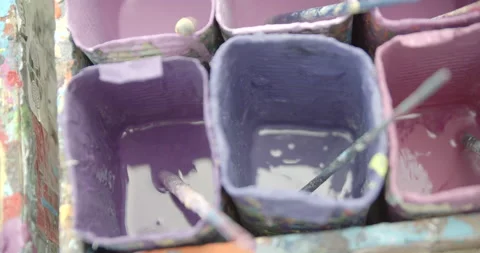 Side view of painting a mural on a wall with brush and roller and palette. Video stock 141754068