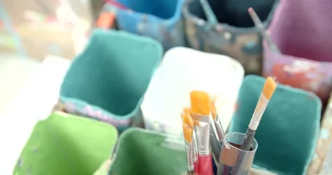 Side view of painting a mural on a wall with brush and roller and palette. Video stock 141754313