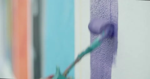 Side view of painting a mural on a wall with brush and roller and palette. Video stock 141754744