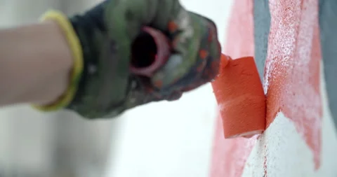 Side view of painting a mural on a wall with brush and roller and palette. Video stock 141757544