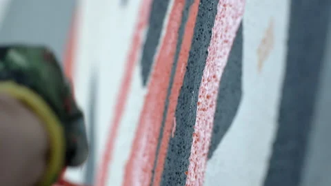 Side view of painting a mural on a wall with brush and roller and palette. Stock Footage 141765972