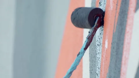 Side view of painting a mural on a wall with brush and roller and palette. Stock Footage 141766507
