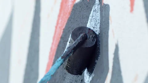 Side view of painting a mural on a wall with brush and roller and palette. Stock Footage 141766571